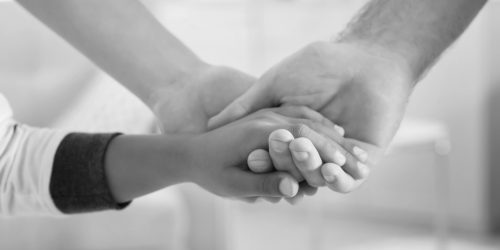 Two hands of parents holding a kid's hand